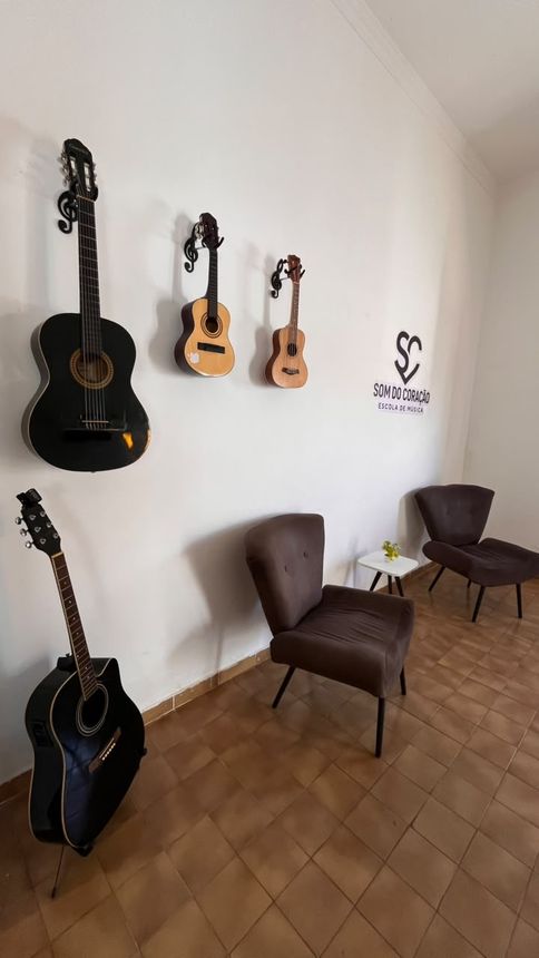 Sala de espera com violões na parede e poltronas