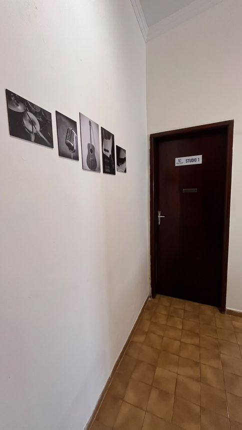 Porta do Studio 1, com quadros de instrumentos no corredor